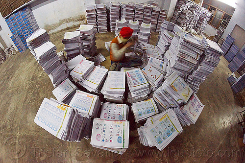 print shop worker collating leaflets into booklets, booklets, books, collating, fisheye, leaflets, lucknow, man, print shop, printed pages, printed paper, stacked, stacks, worker, working