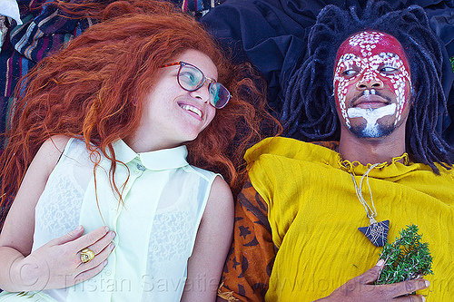 redhead woman - man with african tribal face paint, african american man, african face paint, black man, curly hair, dreadlocks, eyeglasses, eyewear, face painting, facepaint, glasses, herbs, jason, laying down, long hair, lulu, makeup, red, redhead, spectacles, stone necklace, triangular necklace, tribal face paint, white, woman, yellow tunic