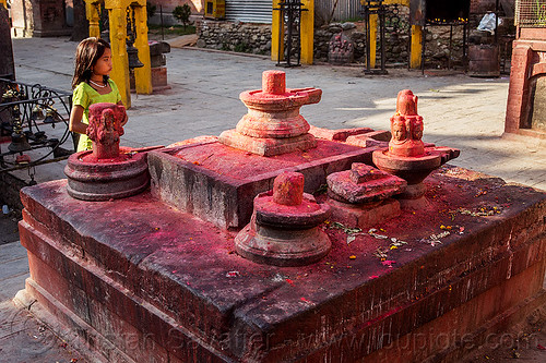 shiva lingas with red dye powder - budhanikantha temple (nepal), budhanikantha temple, child, dyes, girl, hindu temple, hinduism, kid, lingams, red, shiva linga, shiva lingam, shivling