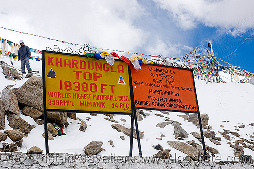 signs with incorrect (inflated) elevation - khardungla pass - ladakh (india), border roads organisation, bro road signs, buddhism, khardung la pass, ladakh, mountain pass, mountains, prayer flags, snow, tibetan