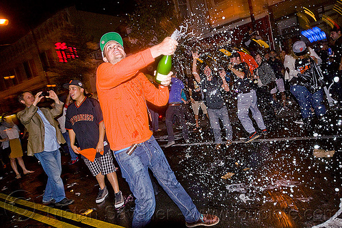 spraying champagne - sf giants fans celebrating, 2012 world series, alcohol, baseball fans, celebrating, champagne, crowd, editorial, go giants, man, night, partying, sf giants, sparkling wine, sports fans, spraying, street party