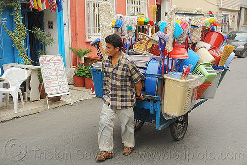 street vendor pulling cart with plastic houseware, basin, buckets, jars, man, mops, pastic houseware, plastic, street seller, street vendor