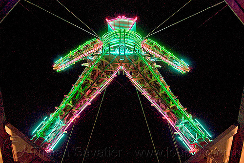 the burning man viewed from the top of the tower, burning man at night, neon lights, the man