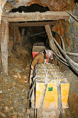 trolley carrying ore out of the mine, adit, batteries, beams, bolivia, cerro rico, electric, man, mina candelaria, mine tunnel, mine worker, miner, mining, pipes, potosí, safety helmet, trolley, underground mine, wood