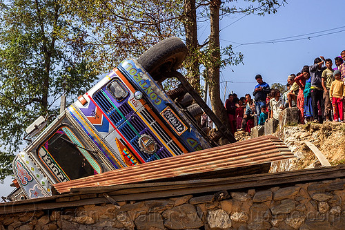 villagers looking at overturned truck (nepal), corrugated metal, crash, ditch, lorry accident, mountain road, overturned, rollover, tata motors, traffic accident, truck accident, up-side-down, wreck