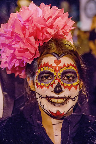 woman with sugar skull makeup and big red flower in hair - dia de los muertos (san francisco), day of the dead, dia de los muertos, face painting, facepaint, flower headdress, halloween, night, red color, sugar skull makeup, woman