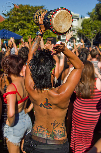 woman with tattooed back playing djembe drum, back tattoo, djembe drum, drumming, gay pride festival, jenn, playing, tattoos, woman