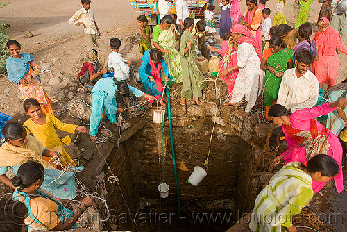women scooping water with buckets at village water well - ajanta (india), ajanta, buckets, communal water well, crowd, drought, pulling water, ropes, villagers, water jars, women