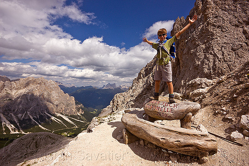 young boy at passo delle coronelle mountain pass - tschager joch - dolomites (italian alps), alps, bench, boy, dolomites, dolomiti, hiking, landscape, marker, mountaineering, mountains, sign, trail, trekking