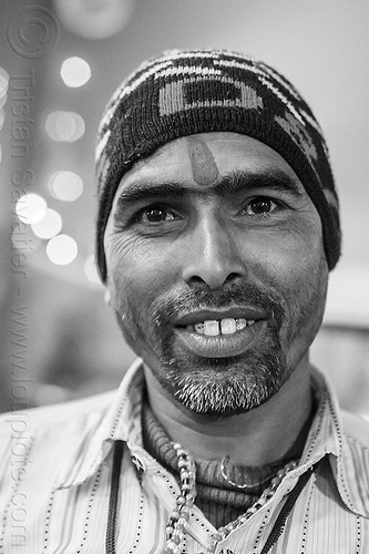 young hindu man at kumbh mela 2013 (india), beard, headwear, hindu man, hindu pilgrimage, hinduism, indian man, knitcap, kumbh mela, night, pilgrim, tilak, tilaka