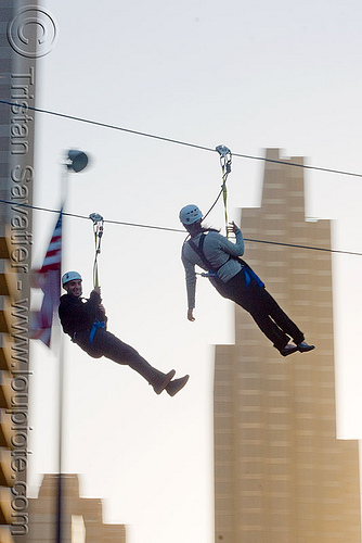 zip-line over san francisco, adventure, american flag, buildings, cable line, cables, climbing helmet, embarcadero, flag pole, hanging, high-rise, mountaineering, moving fast, speed, steel cable, tower, trolley, tyrolienne, urban, us flag, zip line, zip wire