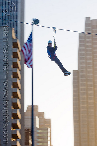 zip-line over san francisco, adventure, american flag, blue sky, buildings, cable line, cables, climbing helmet, embarcadero, flag pole, hanging, high-rise, mountaineering, moving fast, speed, steel cable, tower, trolley, tyrolienne, urban, us flag, zip line, zip wire