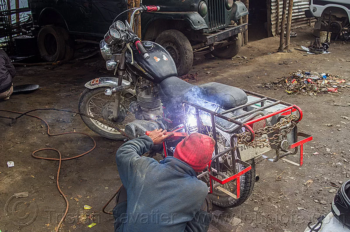 arc welding repair on bullet motorbike rack, india Stock Photo