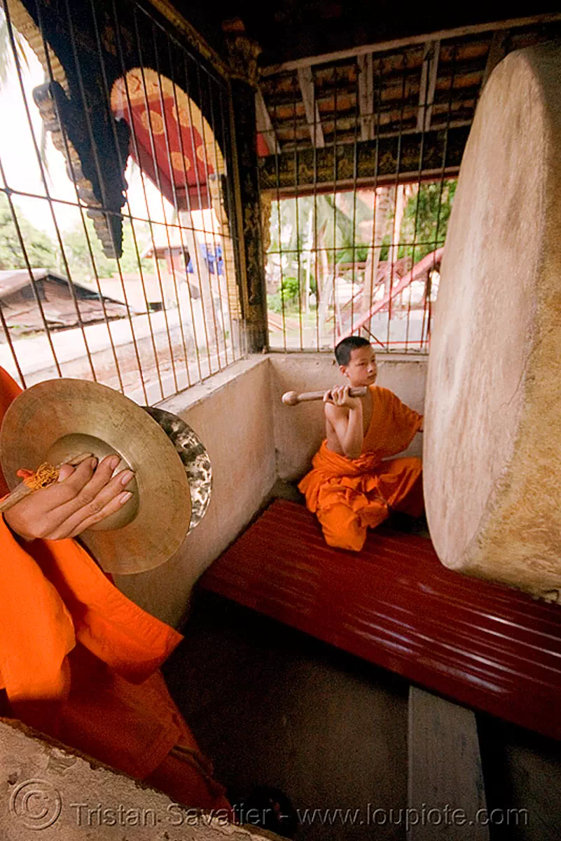 buddhist monk with big drum, luang prabang, laos