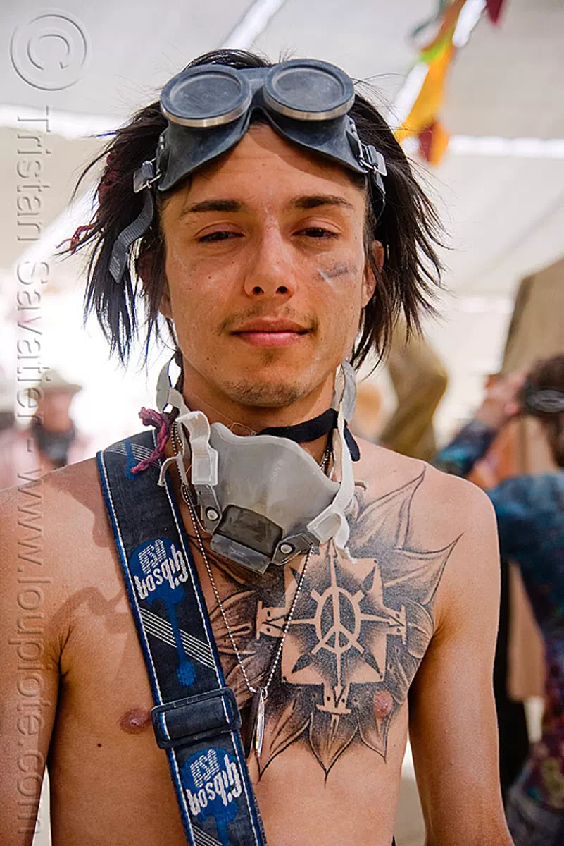 burner with chest tattoo at center camp cafe - burning man 2009, burning man, chest tattoo, flower tattoo, goggles, peace sign tattoo, tattooed, tattoos, trent