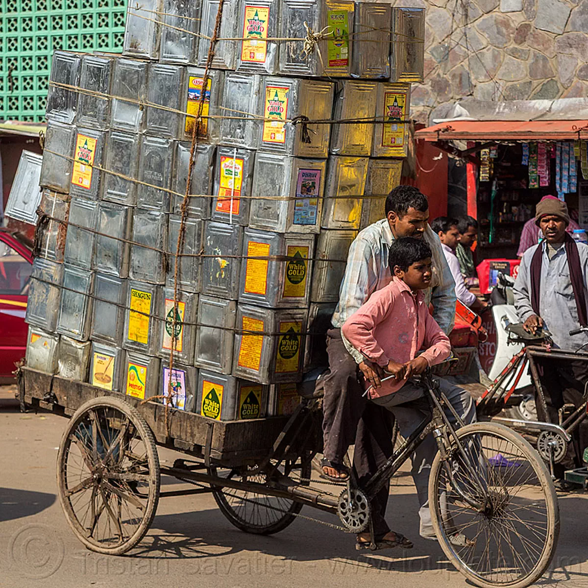 cargo tricycle loaded with metal oil boxes, india