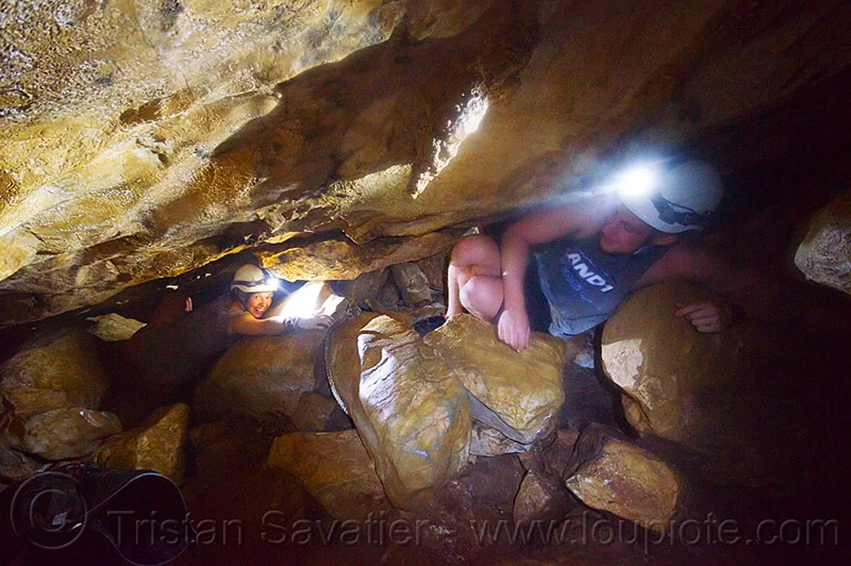 cavers in a squeeze - caving in mulu (borneo), borneo, cavers, caving, clearwater cave system, clearwater connection, gunung mulu national park, malaysia, natural cave, spelunkers, spelunking, squeeze