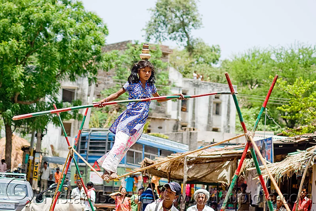circus performer in village, young girl balancing on slack rope, near udaipur, india