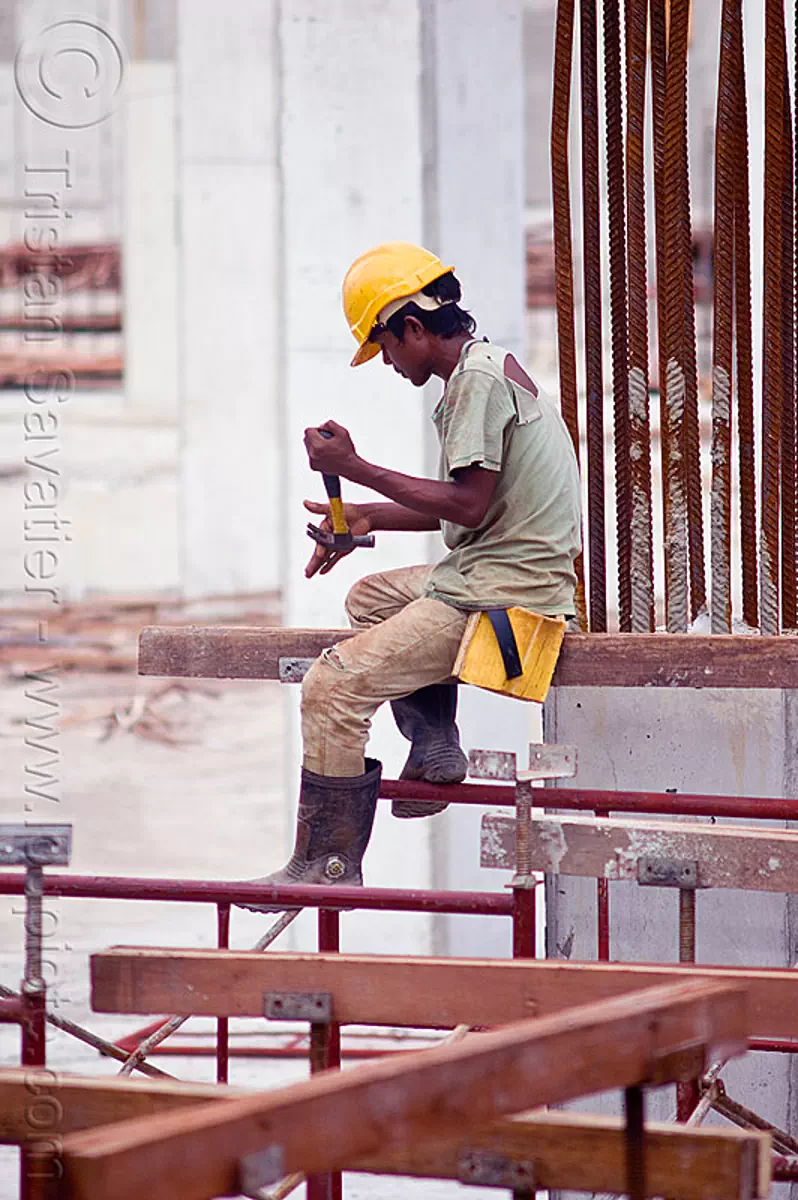 construction worker on shoring scaffolding, borneo, building construction, construction site, construction workers, hammer, lumber, malaysia, man, miri, rebars, safety helmet, scaffolding, shoring, sitting, timber