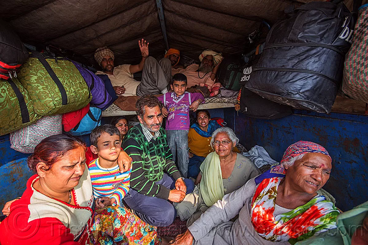 family of hindu pilgrims returning home in the back of a truck - kumbh mela (india), chil, children, exodus, family, hindu pilgrimage, hinduism, kids, kumbh mela, lorry, luggage, men, truck, women
