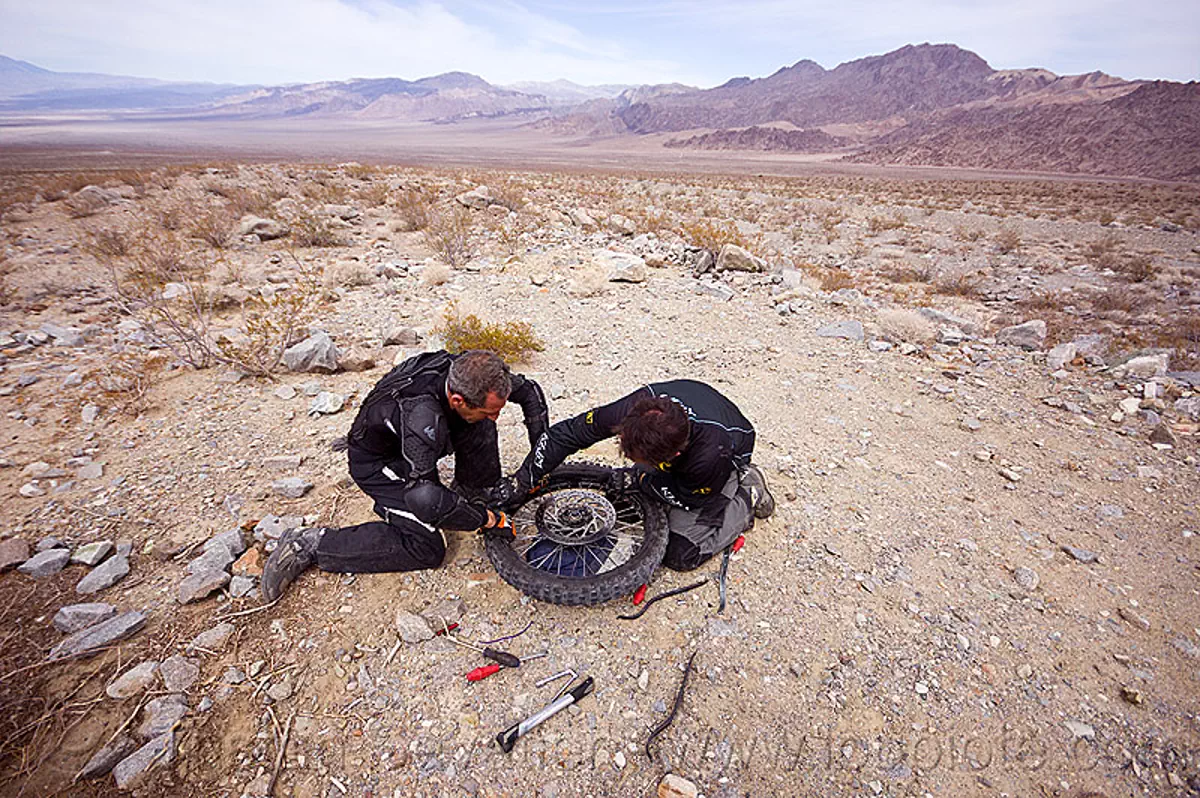 fixing a motorcycle flat tire in the desert
