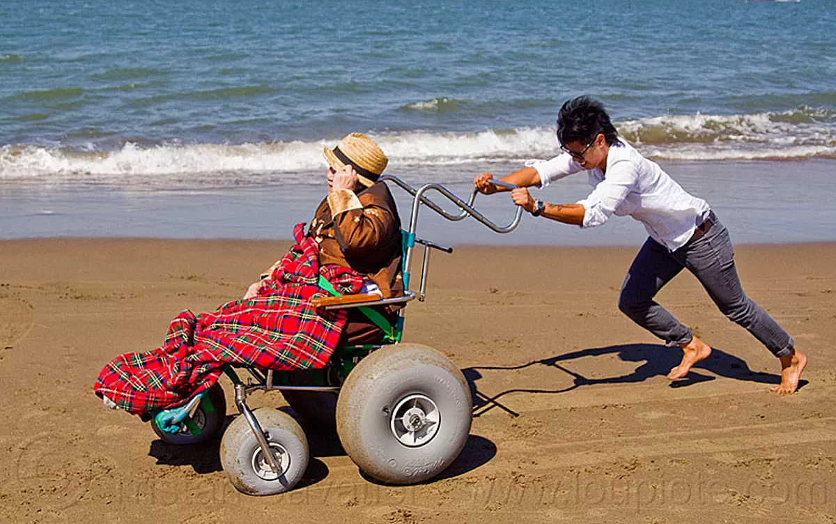 granddaughter pushing her grandma's beach wheelchair on the beach, beach wheelchair, blanket, chinese, crissy field beach, family, grandma, grandmother, jenn, old woman, rolling, sand, senior, straw hat, women