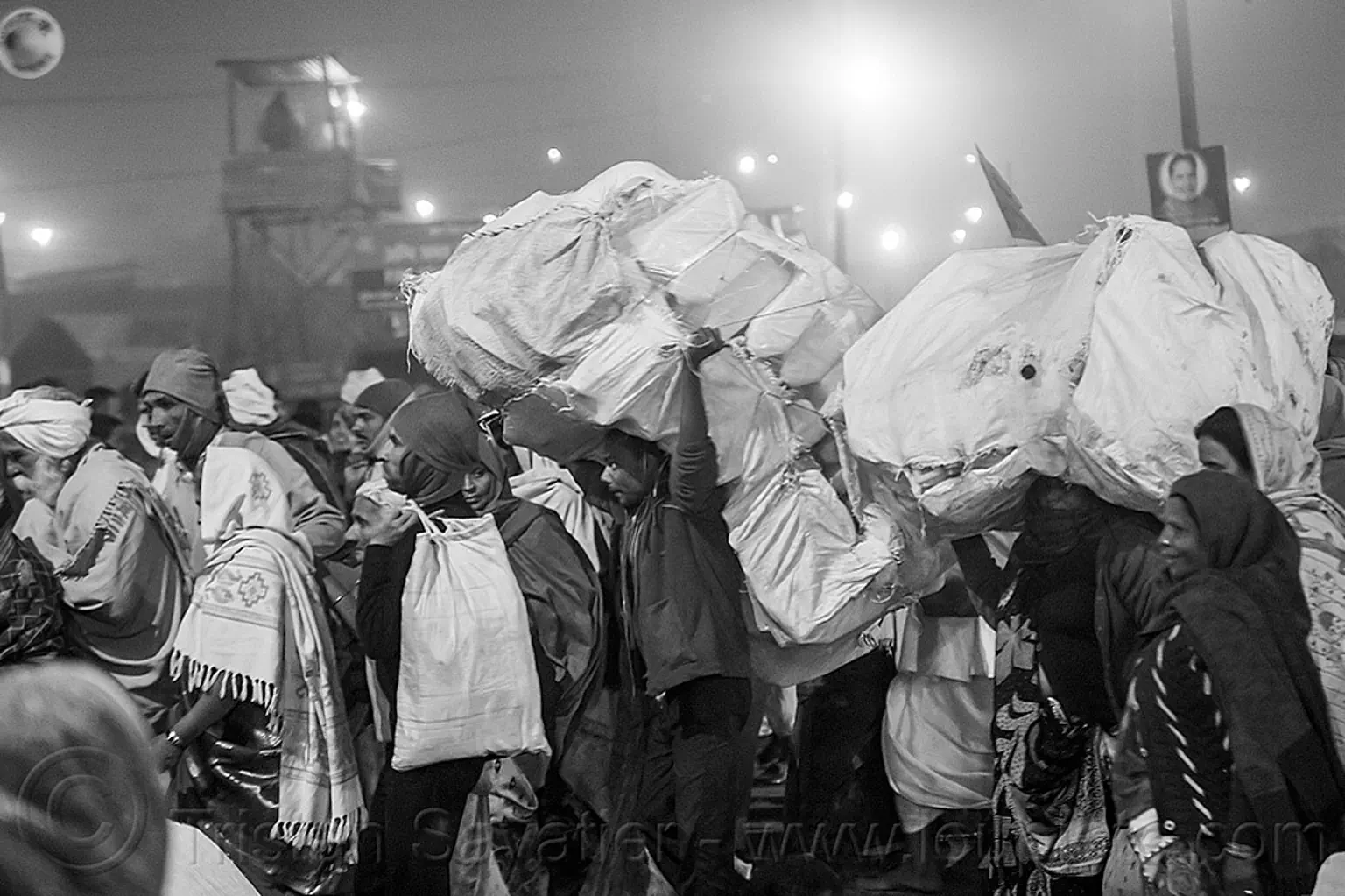 hindu pilgrims and street vendors carrying large sacks, india