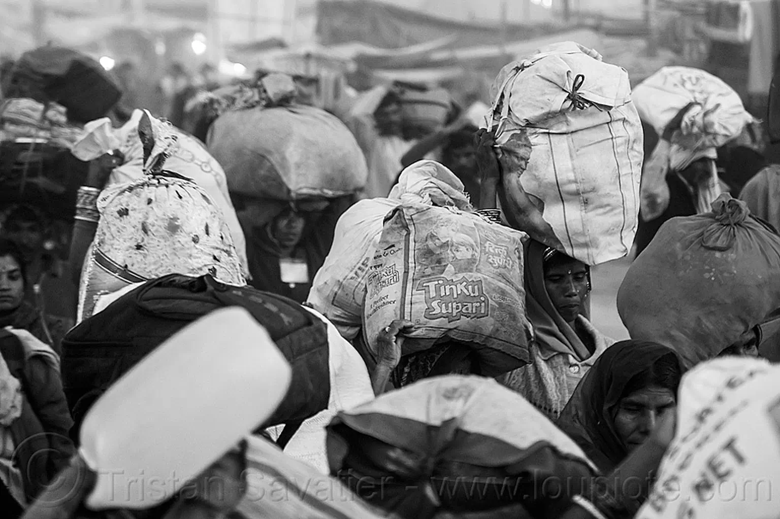 hindu pilgrims carrying bags over their heads, kumbh mela, india