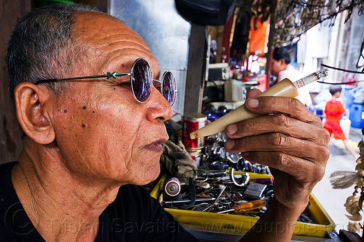 horn cigarette holder, cigarette holder, hand, man, smoker, smoking, street seller, street vendor, sunglasses
