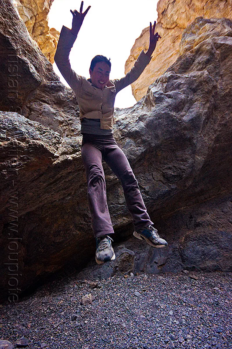 jumping down - grotto canyon, death valley, grotto canyon, jump, jumper, jumping down, jumpshot, mountain, peace sign, rock, slot canyon, woman