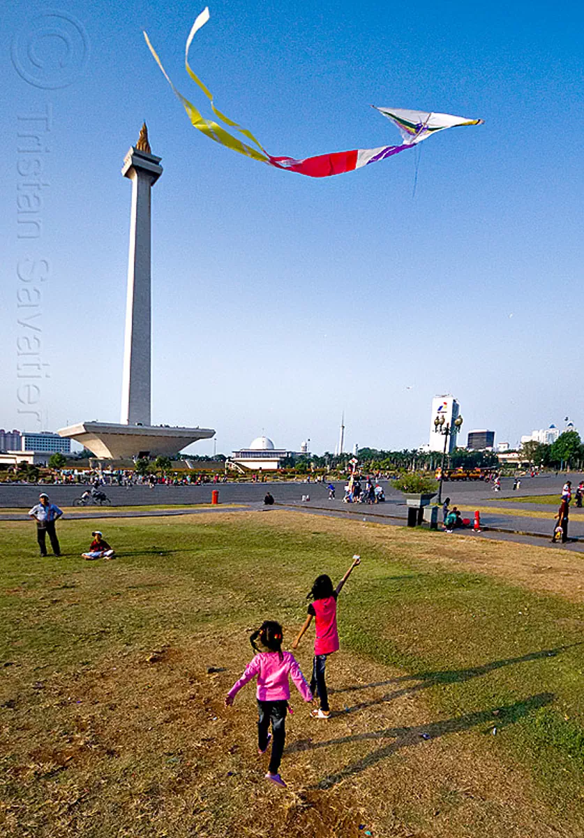 kids flying a kite near the national monument (monas) in jakarta, architecture, children, column, eid ul-fitr, flying, indonesia, jakarta, kids, kite, lawn, medan merdeka, merdeka square, monumen nasional, national monument, park