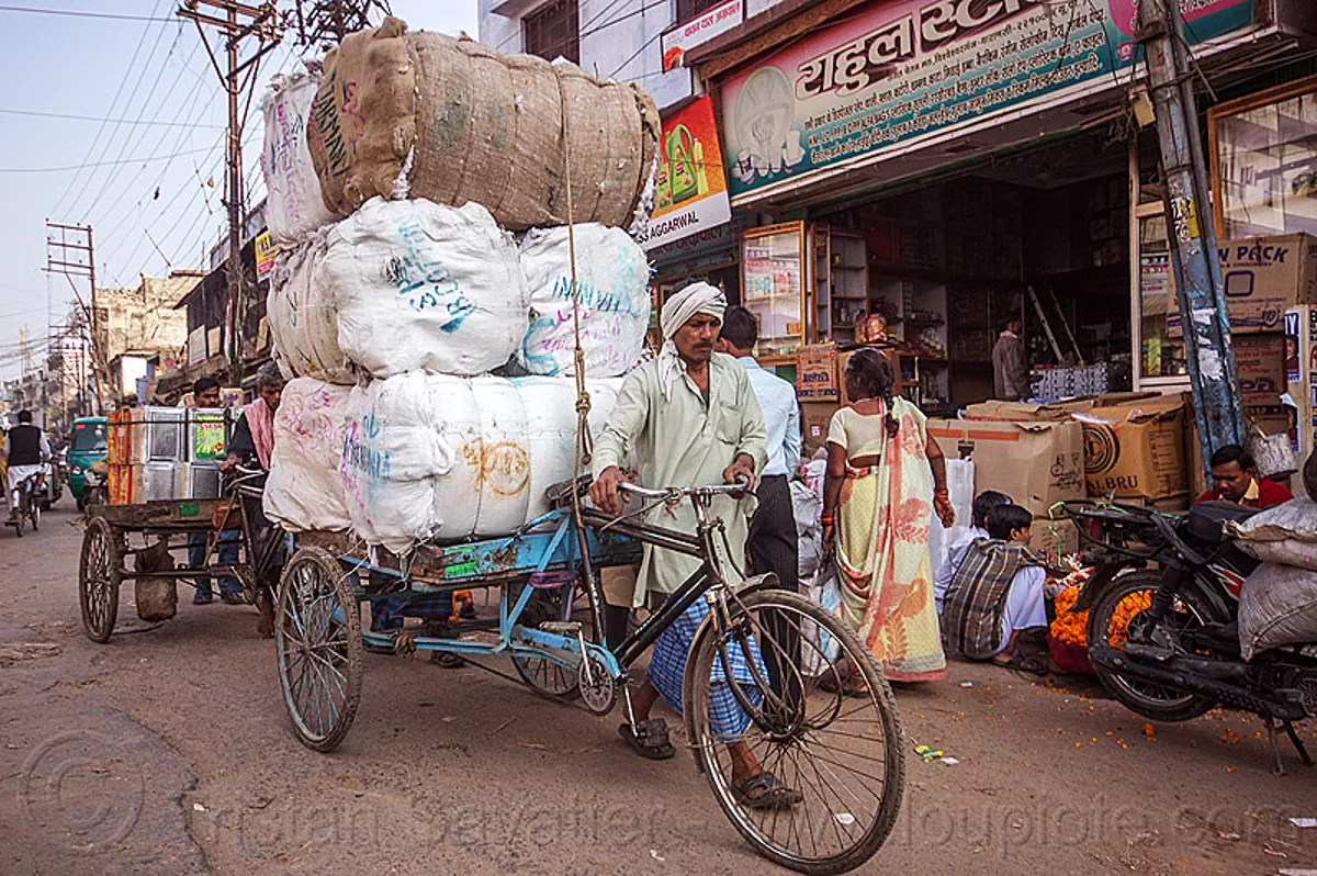 man-walking-cargo-tricycle-with-heavy-load-of-freight-india-11284979425.jpg