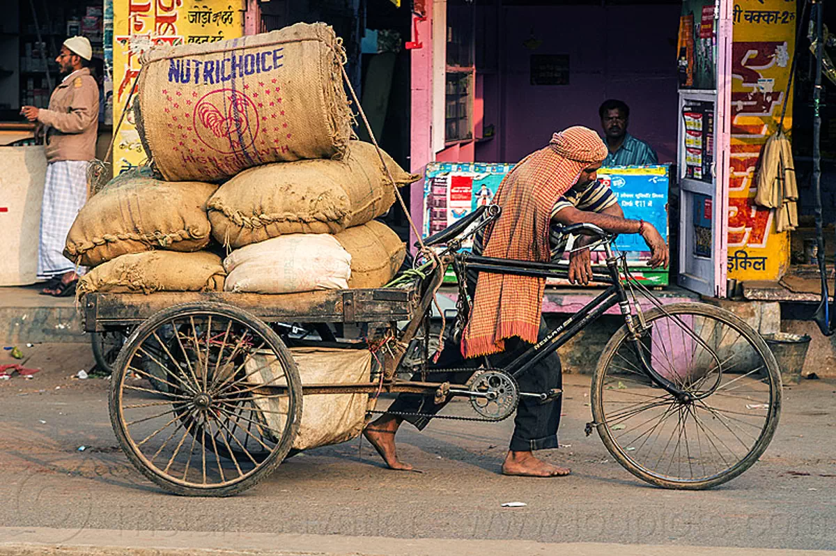 man-with-heavy-load-of-freight-on-cargo-tricycle-india-11285043976.jpg