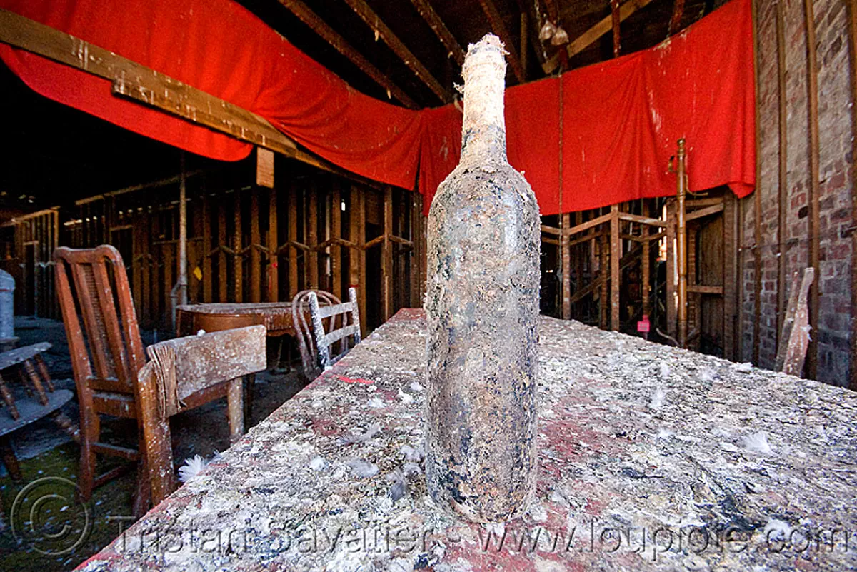 old bottle of wine on table in abandoned building, chairs, defenestration building, pigeon droppings, red, table, wine
