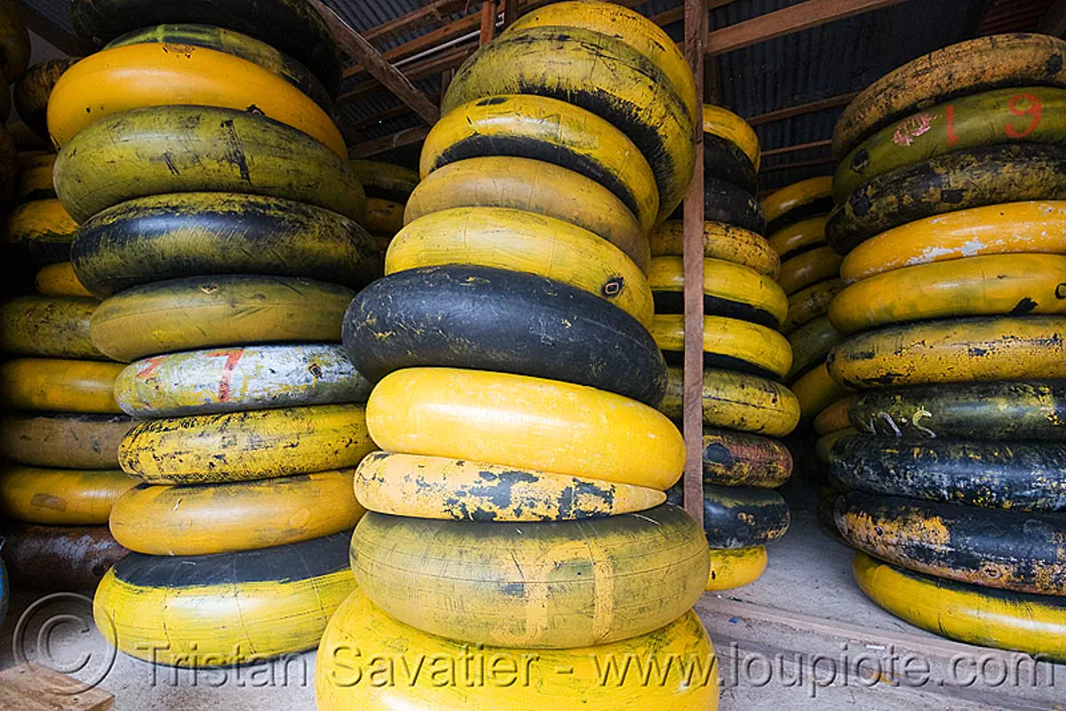 river tubing in vang vieng (laos), inner tubes, laos, river tubing, stacked, stacks, vang vieng, yellow