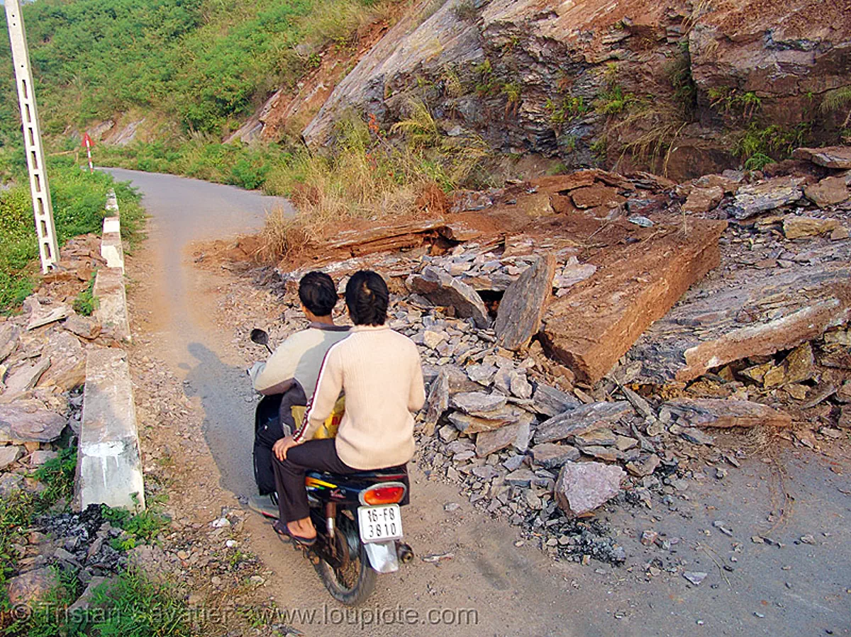 road blocked by landslide, cat ba island, cát bà, debris, falling rocks, landslide, men, motorcycle, rider, riding, road blocked, road closed, vietnam
