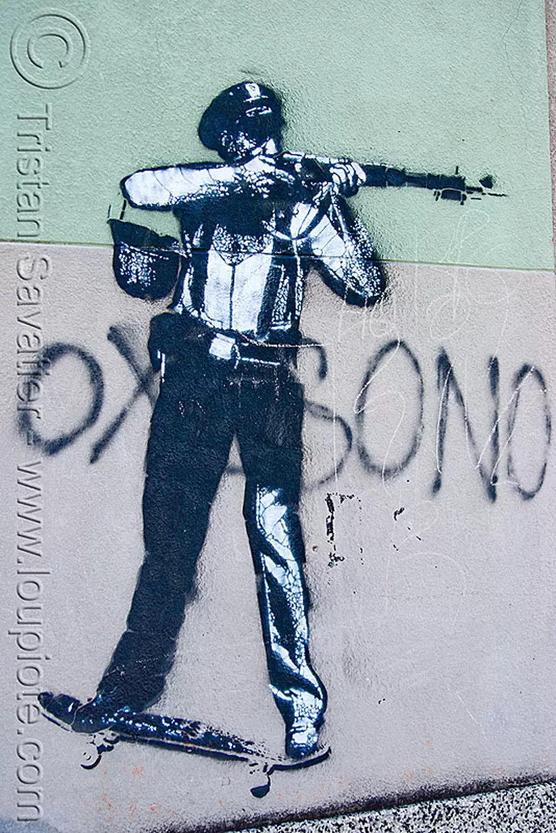 stencil graffiti - police on skateboard shooting a rifle, argentina, buenos aires, cop, graffiti, hand gun, la boca, law enforcement, police, rifle, shooting, shot gun, skateboard, stencil, street art