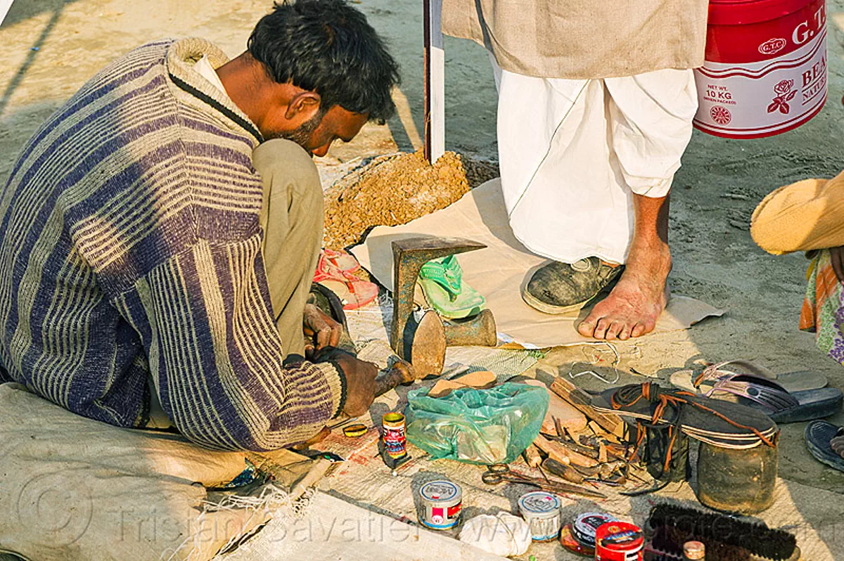 street shoemaker repairing a shoe, india