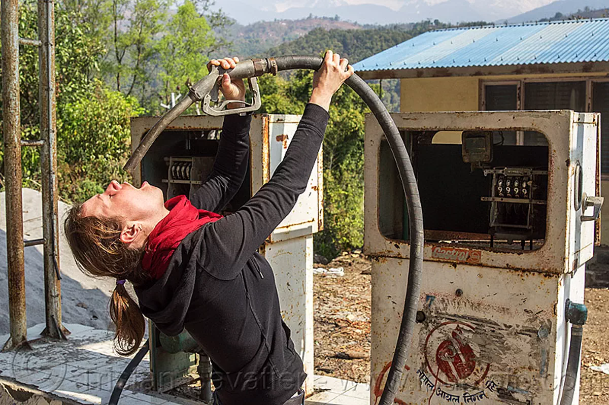 thirsty woman drinks at the petrol pump, nepal Stock