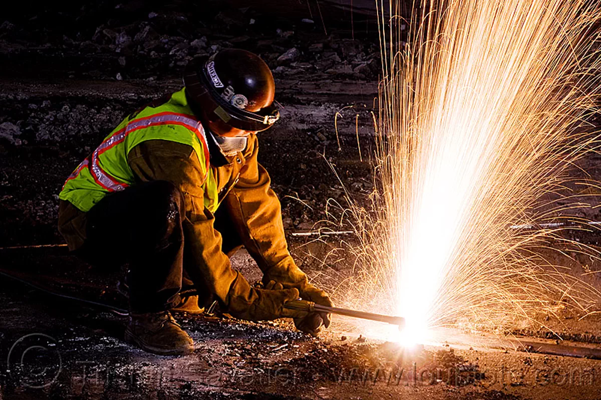 welder cutting a train rail with an oxyacetylene torch