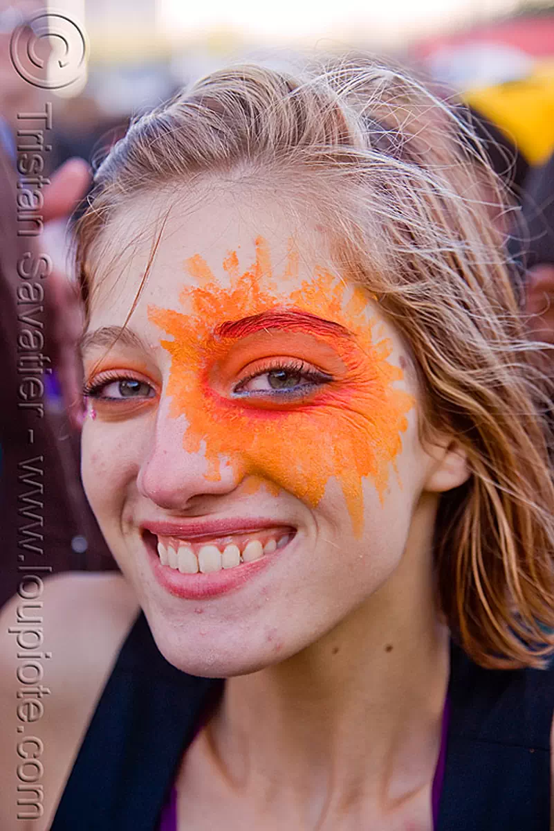 woman with orange face paint, sun, eye