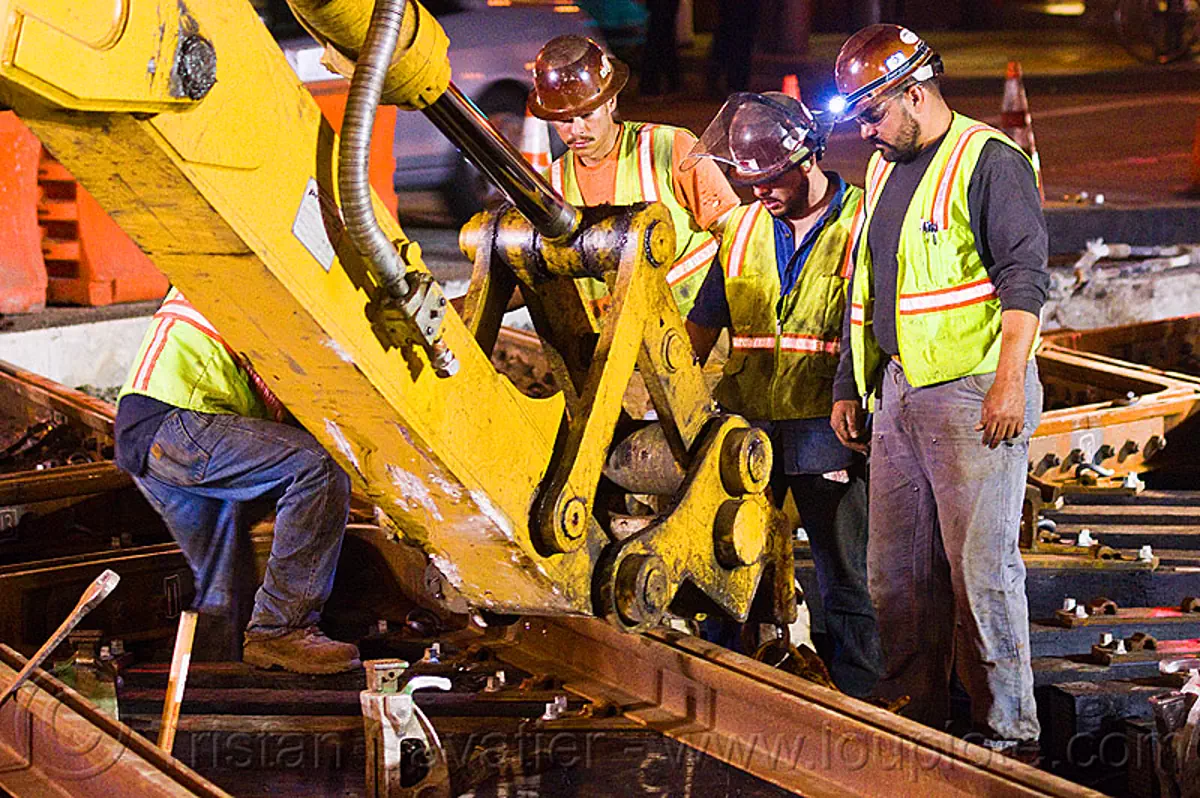 workers adjusting new track rail segment
