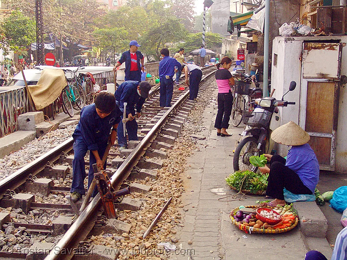 workers on train tracks in hanoi, vietnam