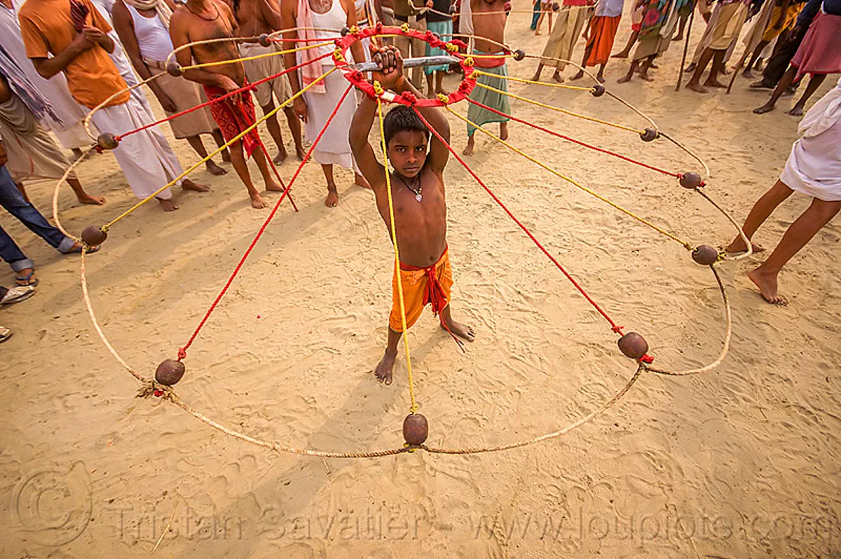 young hindu boy spinning balls with ropes (india), boy, game, hindu pilgrimage, hinduism, indian spinning balls, kumbh mela, metal balls, performer, ropes