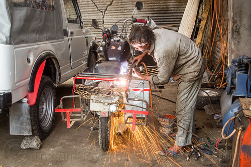 arc welding repair on motorbike (india), 350cc, arc welding, fixing, man, mechanic, motorcycle, repairing, royal enfield bullet, shock absorber, sikkim, sparks, thunderbird, welder, worker, working