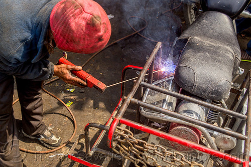arc welding repair on motorbike luggage rack (india), 350cc, arc welding, fixing, luggage rack, man, mechanic, motorcycle, repairing, royal enfield bullet, sikkim, thunderbird, welder, worker, working