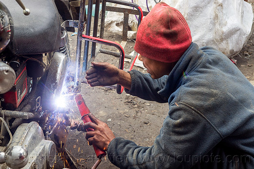 arc welding repair on motorbike rack (india), 350cc, arc welding, fixing, luggage rack, man, mechanic, motorcycle, repairing, royal enfield bullet, sikkim, sparks, thunderbird, welder, worker, working