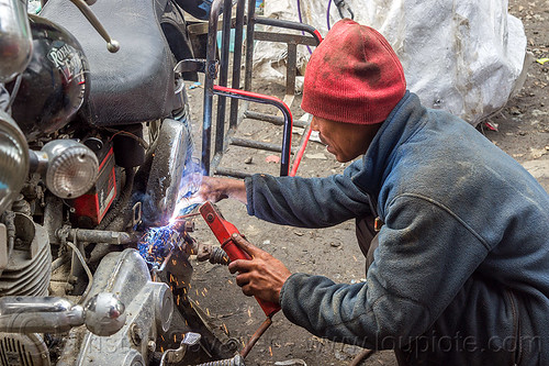 arc welding repair on royal enfield motorcycle rack (india), 350cc, arc welding, fixing, luggage rack, man, mechanic, motorcycle, repairing, royal enfield bullet, sikkim, sparks, thunderbird, welder, worker, working