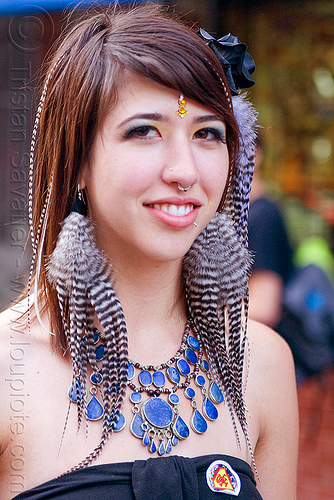 ariana francesca with her striped feather earrings, ariana francesca, bindi, blue stone necklace, feather earrings, woman