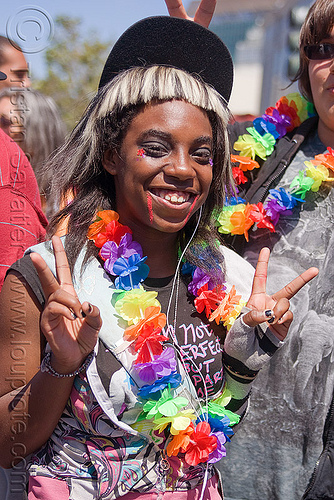 black teen girl at the san francisco gay pride, black woman, flower necklace, gay pride festival, girl, peace sign, rainbow colors, rainbow necklace, v sign, victory sign